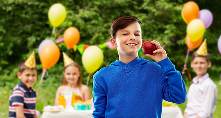 Image showing smiling boy with red apple at birthday party