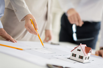 Image showing close up of architects with blueprint at office