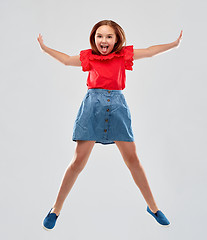 Image showing happy smiling girl in red shirt and skirt jumping