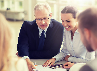 Image showing architects with smartphone and blueprint at office