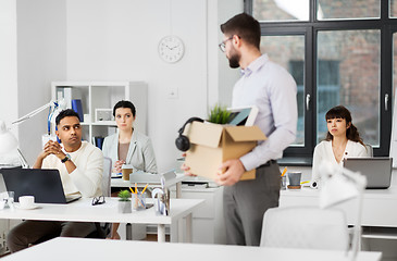 Image showing fired male office worker with personal stuff