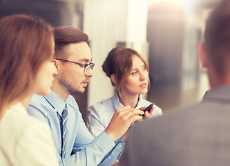 Image showing businessman texting on smartphone at office