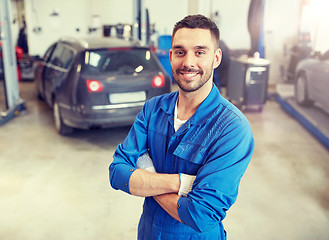 Image showing happy auto mechanic man or smith at car workshop