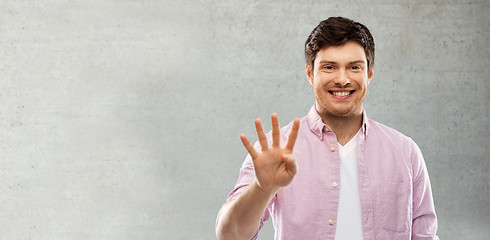 Image showing man showing four fingers over grey concrete wall