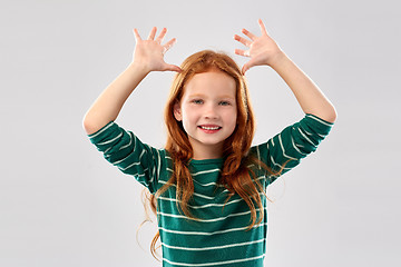 Image showing red haired girl having fun and making big ears