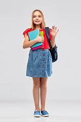 Image showing happy student girl with books and bag waving hand