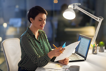 Image showing businesswoman with papers working at night office