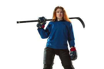 Image showing Young female hockey player with the stick on ice court and white background