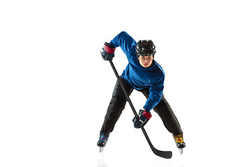 Image showing Young female hockey player with the stick on ice court and white background