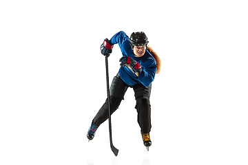 Image showing Young female hockey player with the stick on ice court and white background