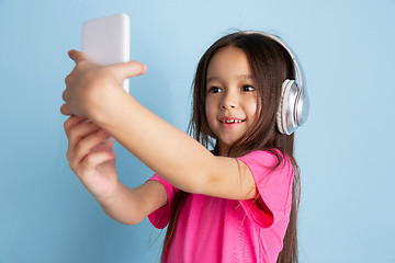 Image showing Caucasian little girl\'s portrait on blue studio background