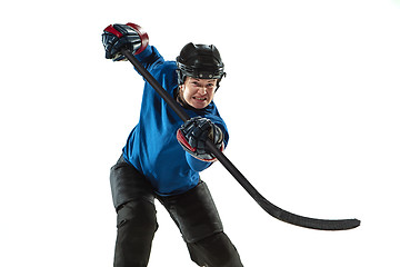 Image showing Young female hockey player with the stick on ice court and white background