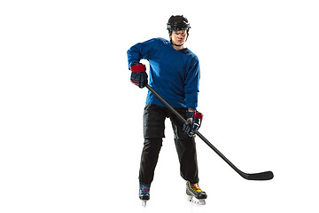 Image showing Young female hockey player with the stick on ice court and white background