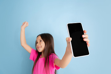 Image showing Caucasian little girl\'s portrait on blue studio background