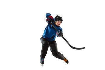 Image showing Young female hockey player with the stick on ice court and white background