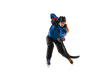 Image showing Young female hockey player with the stick on ice court and white background