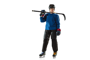 Image showing Young female hockey player with the stick on ice court and white background