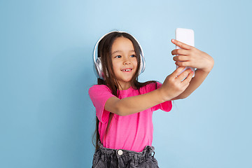 Image showing Caucasian little girl\'s portrait on blue studio background