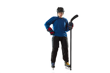 Image showing Young female hockey player with the stick on ice court and white background