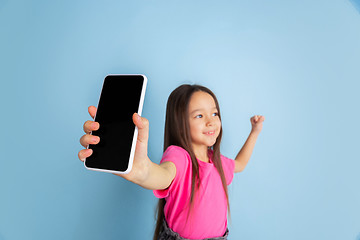 Image showing Caucasian little girl\'s portrait on blue studio background