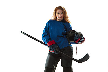 Image showing Young female hockey player with the stick on ice court and white background