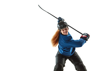 Image showing Young female hockey player with the stick on ice court and white background