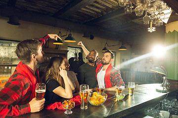 Image showing Sport fans cheering at bar, pub and drinking beer while championship, competition is going