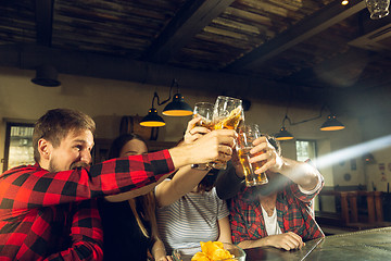 Image showing Sport fans cheering at bar, pub and drinking beer while championship, competition is going