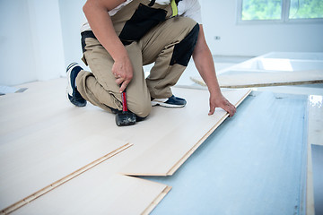 Image showing Professional Worker Installing New Laminated Wooden Floor