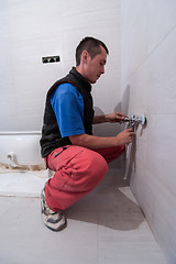 Image showing professional plumber working in a bathroom