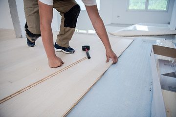 Image showing Worker Installing New Laminated Wooden Floor