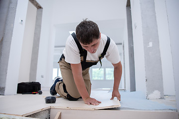 Image showing Worker Installing New Laminated Wooden Floor