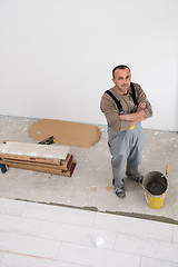 Image showing worker installing the ceramic wood effect tiles on the floor