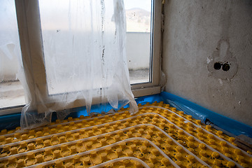 Image showing yellow underfloor heating installation with white pipes