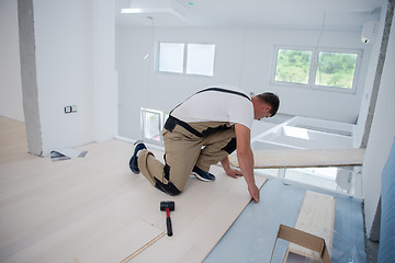 Image showing Worker Installing New Laminated Wooden Floor