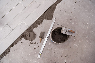 Image showing Ceramic wood effect tiles and tools for tiler on the floor