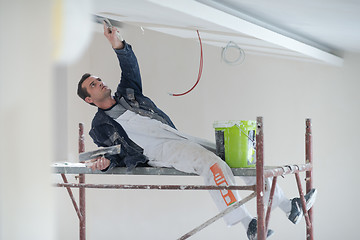 Image showing construction worker plastering on gypsum ceiling