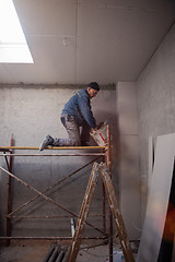 Image showing construction worker plastering on gypsum ceiling