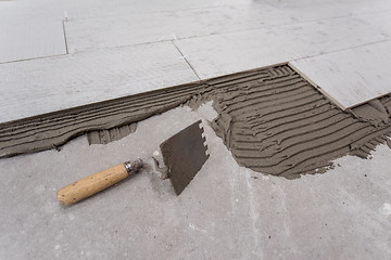 Image showing Ceramic wood effect tiles and tools for tiler on the floor