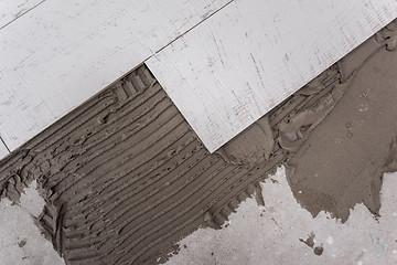 Image showing Ceramic wood effect tiles and tools for tiler on the floor