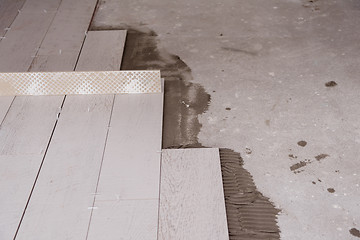 Image showing Ceramic wood effect tiles and tools for tiler on the floor