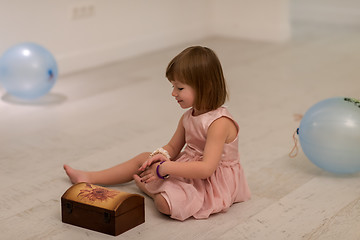Image showing little girl enjoying while playing with mother\'s jewelry