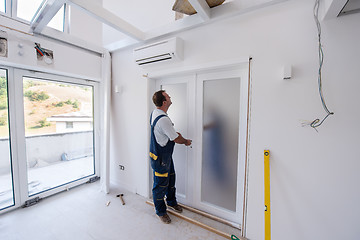 Image showing carpenters installing glass door with a wooden frame