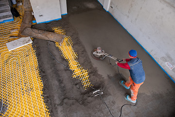 Image showing worker performing and polishing sand and cement screed floor