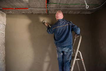 Image showing Worker plastering the wall by concrete