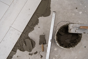 Image showing Ceramic wood effect tiles and tools for tiler on the floor