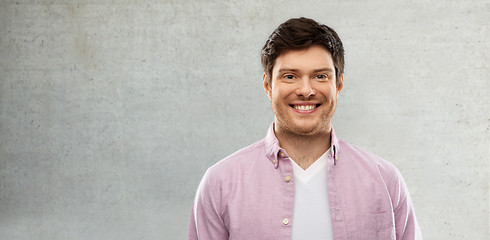 Image showing smiling young man over grey concrete wall