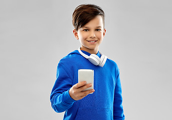 Image showing smiling boy in blue hoodie using smartphone