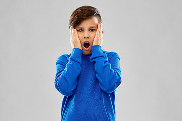 Image showing shocked or scared boy touching face