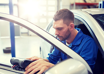 Image showing mechanic man with diagnostic scanner at car shop